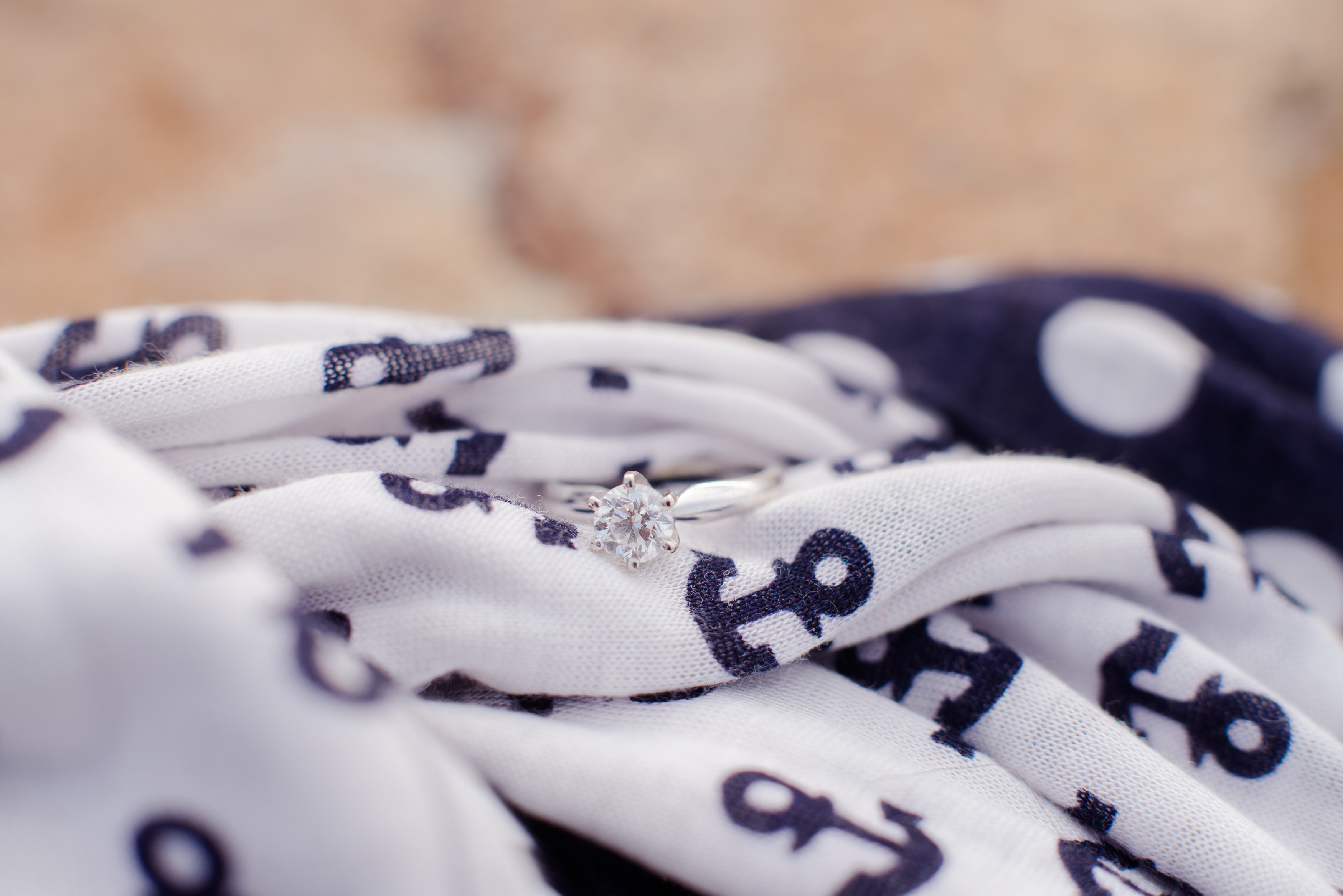 In today's blog post I'm talking about how I changed my name for my photography business, and why I did that! Photo of an engagement ring on a nautical scarf.